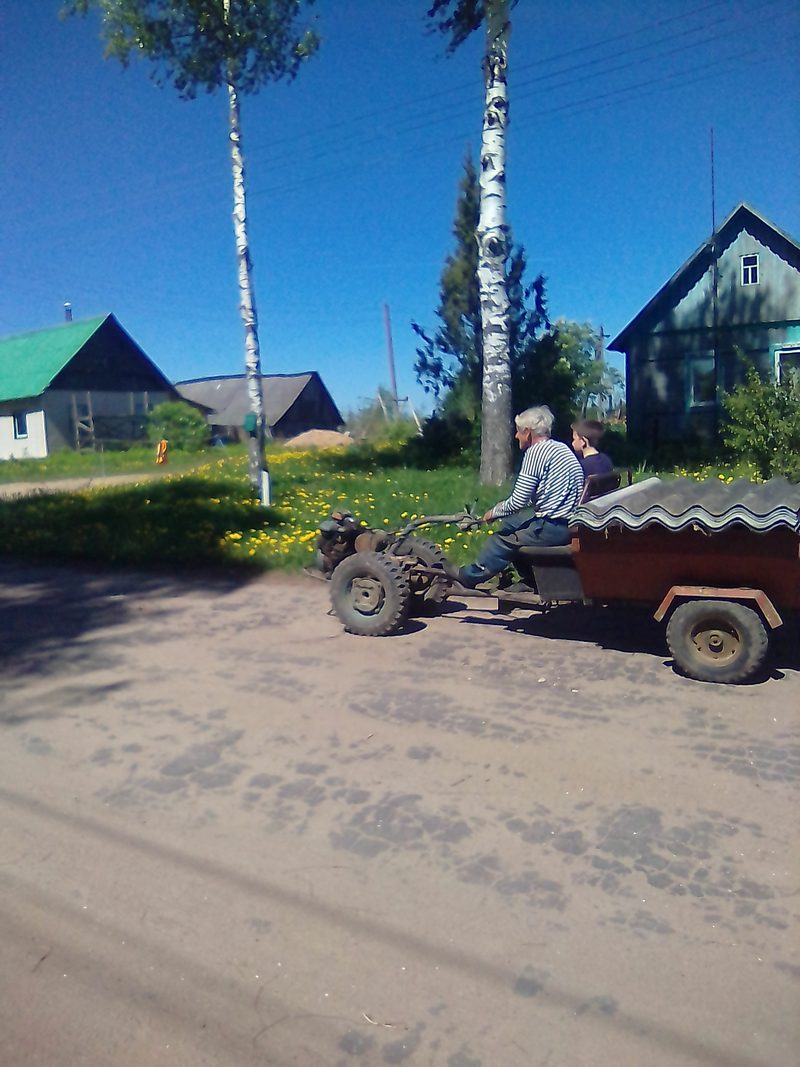 Мотоблок с прицепом на деревенской дороге — кадр к разбору